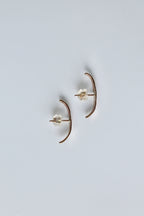 Pair of gold earrings on a light gray background