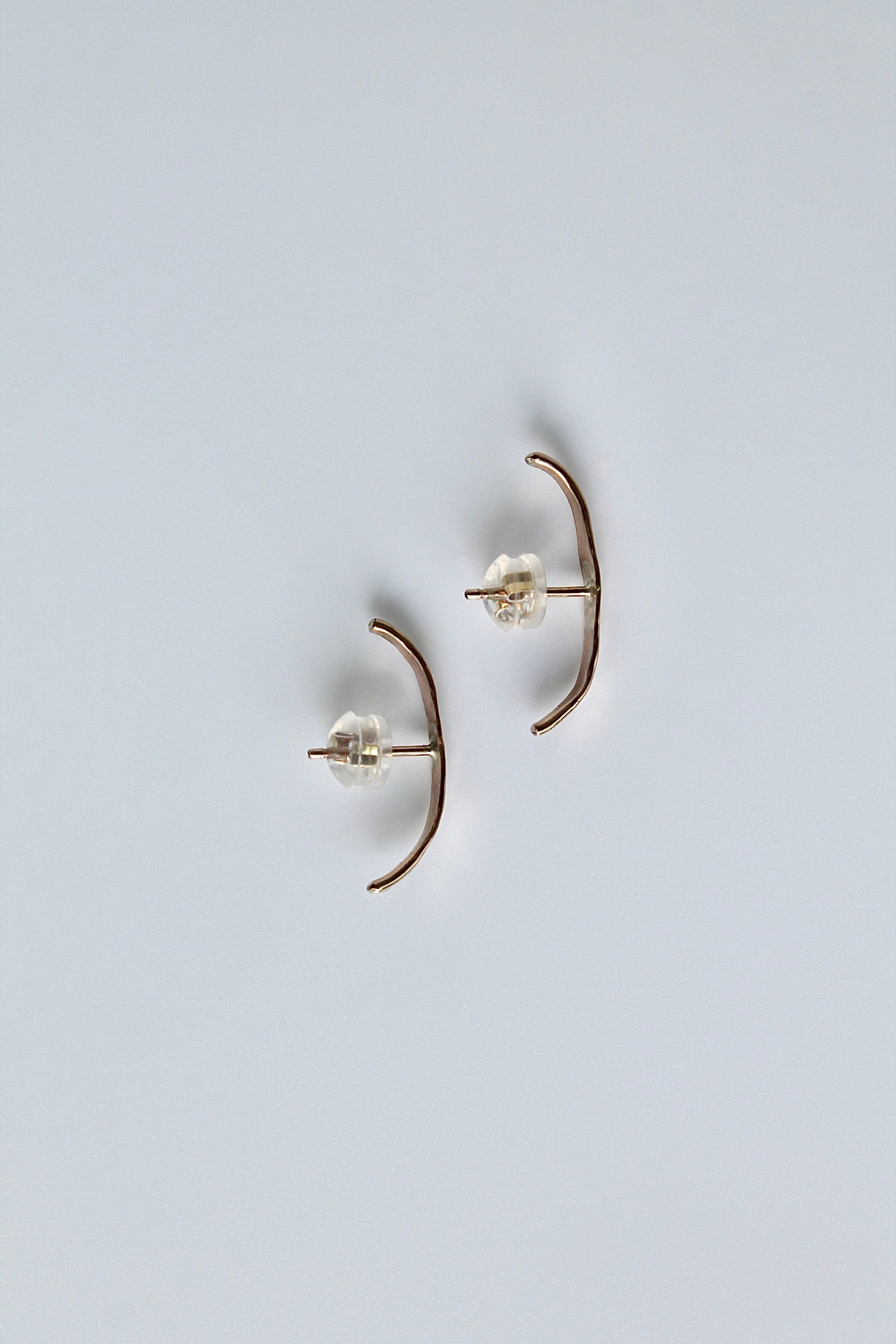 Pair of gold earrings on a light gray background