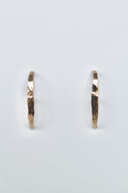 Gold stud earrings on a light gray background
