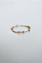 gold fidget spinner ring with gold beads on a white background