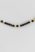 bracelet with black and gold beads on white background