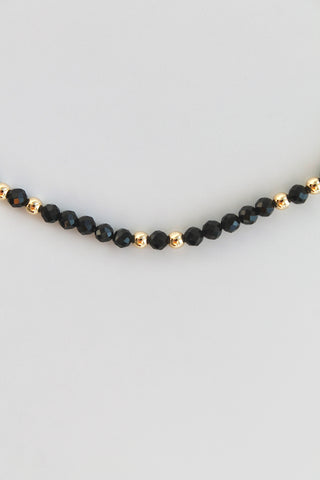 bracelet with black and gold beads on white background
