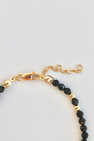 black and gold beaded bracelet clasp on white background