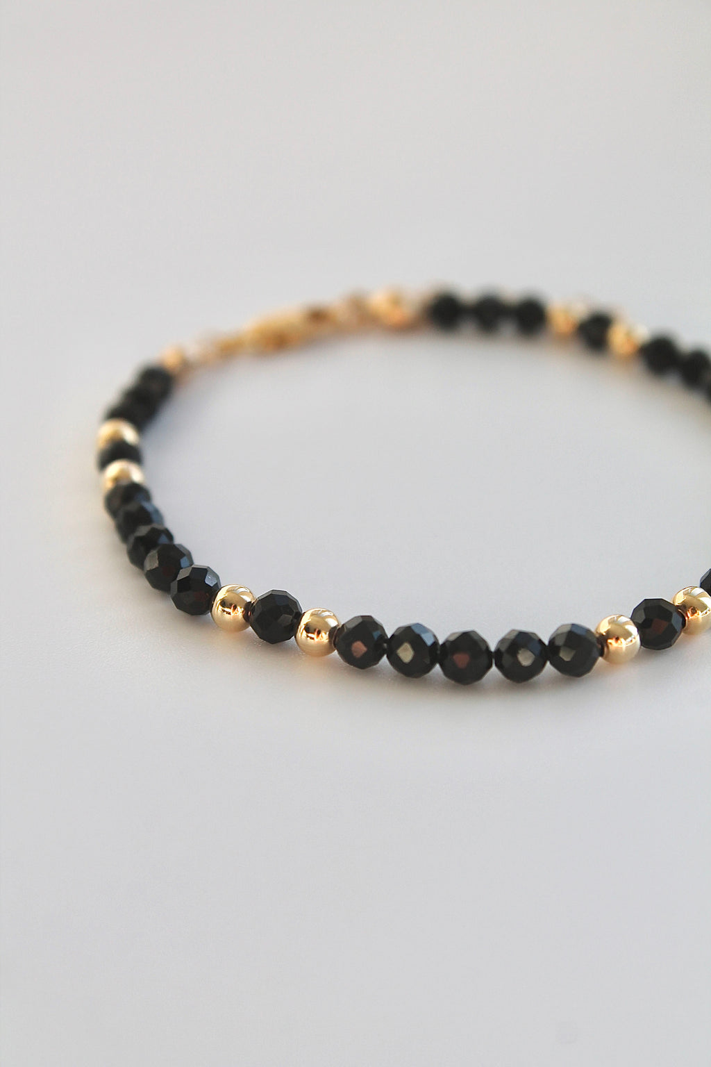 black and gold beaded bracelet close up of beads on white background