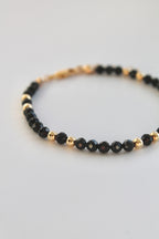 black and gold beaded bracelet close up of beads on white background
