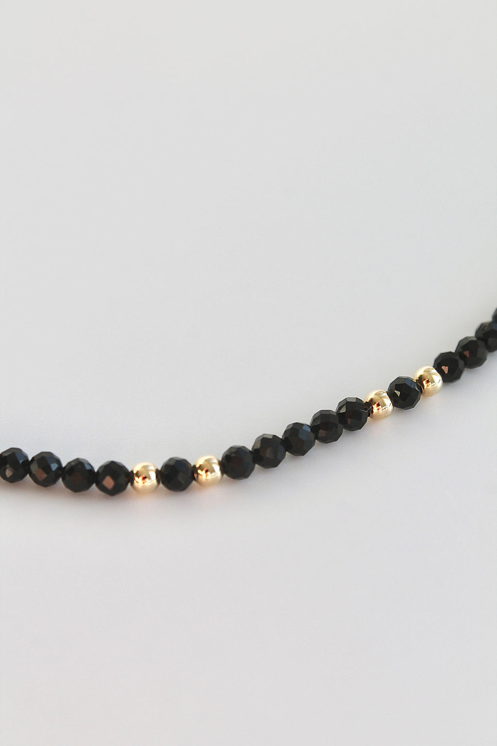 bracelet with black and gold beads on a white background