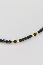 bracelet with black and gold beads on a white background
