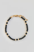 bracelet with black and gold beads from above on white background