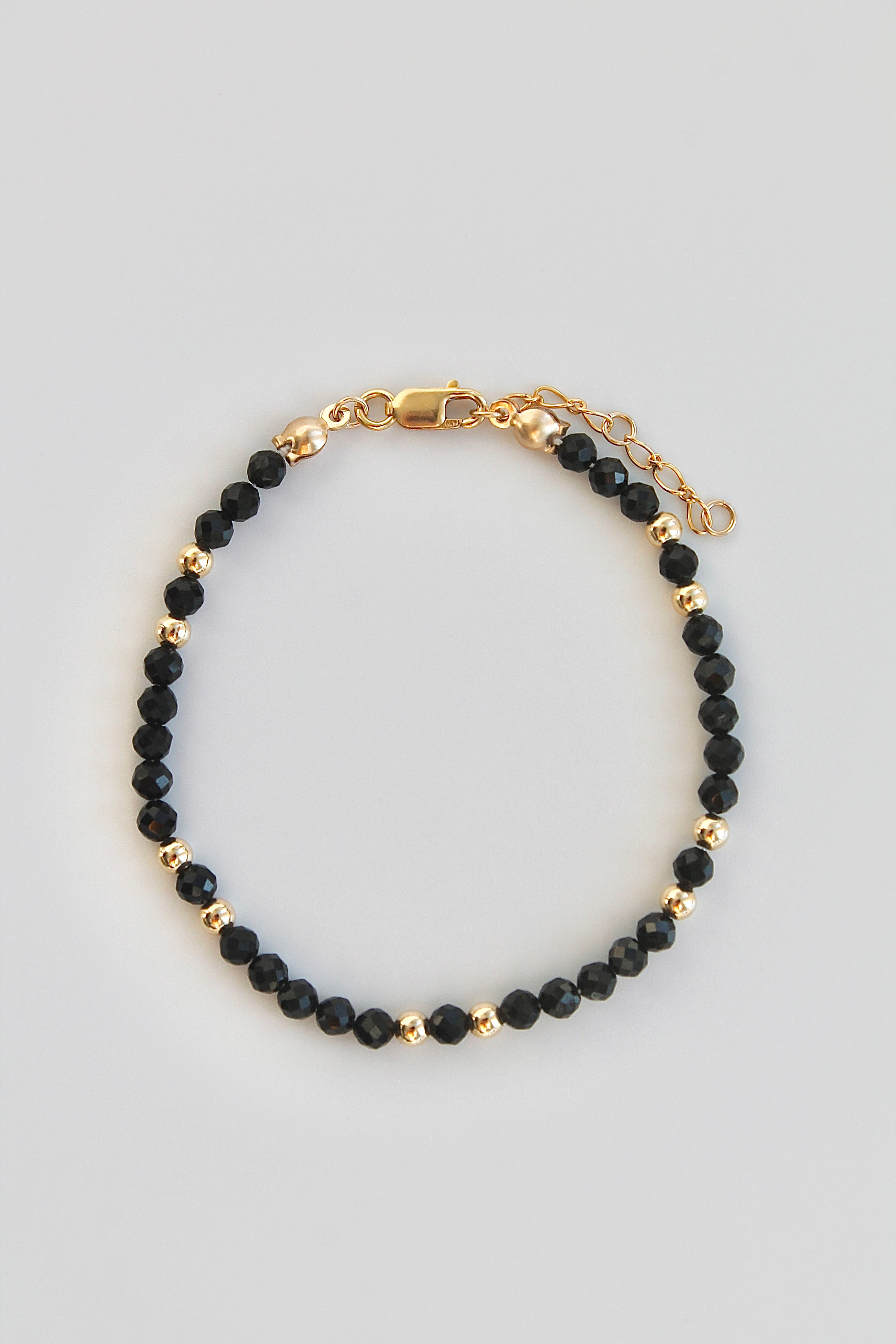 bracelet with black and gold beads from above on white background
