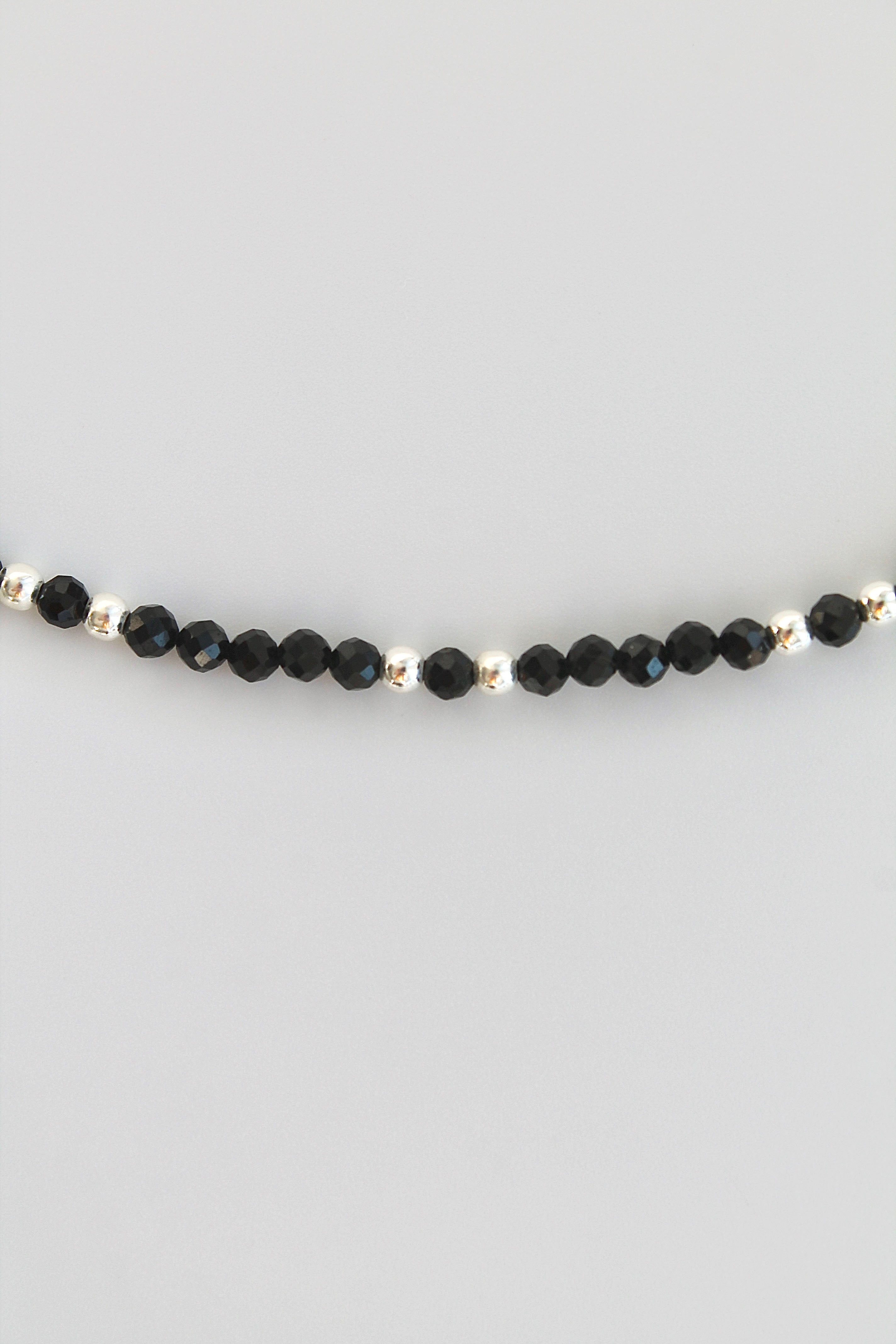 black and silver beaded bracelet on white background