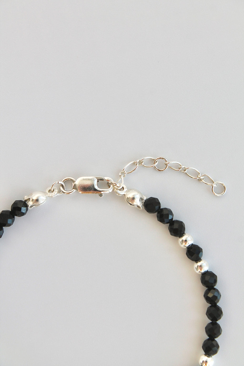 black and silver beaded bracelet close-up of clasp on white background