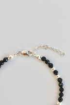 black and silver beaded bracelet close-up of clasp on white background