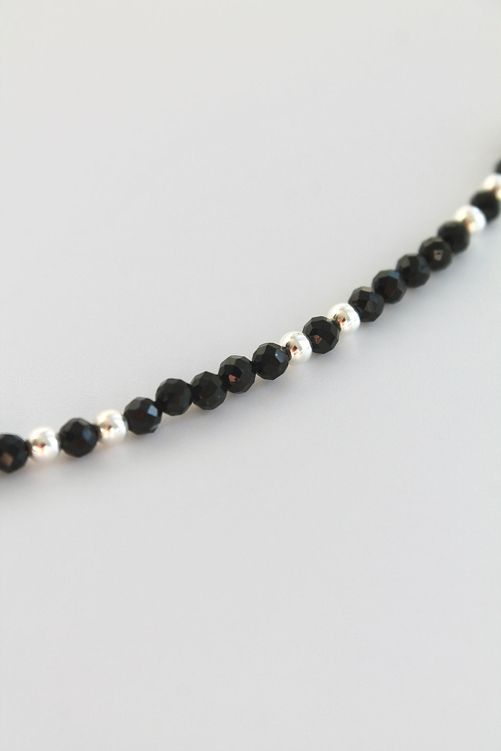 black and silver beaded bracelet on white background