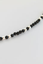 black and silver beaded bracelet on white background