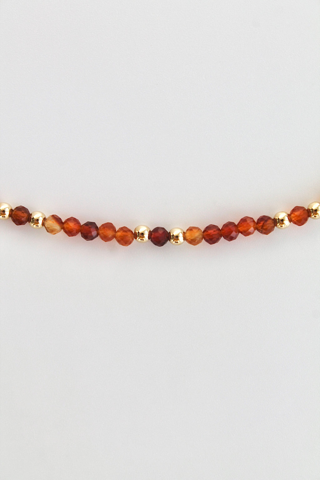 carnelian and gold bead bracelet on a white background