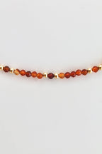 carnelian and gold bead bracelet on a white background