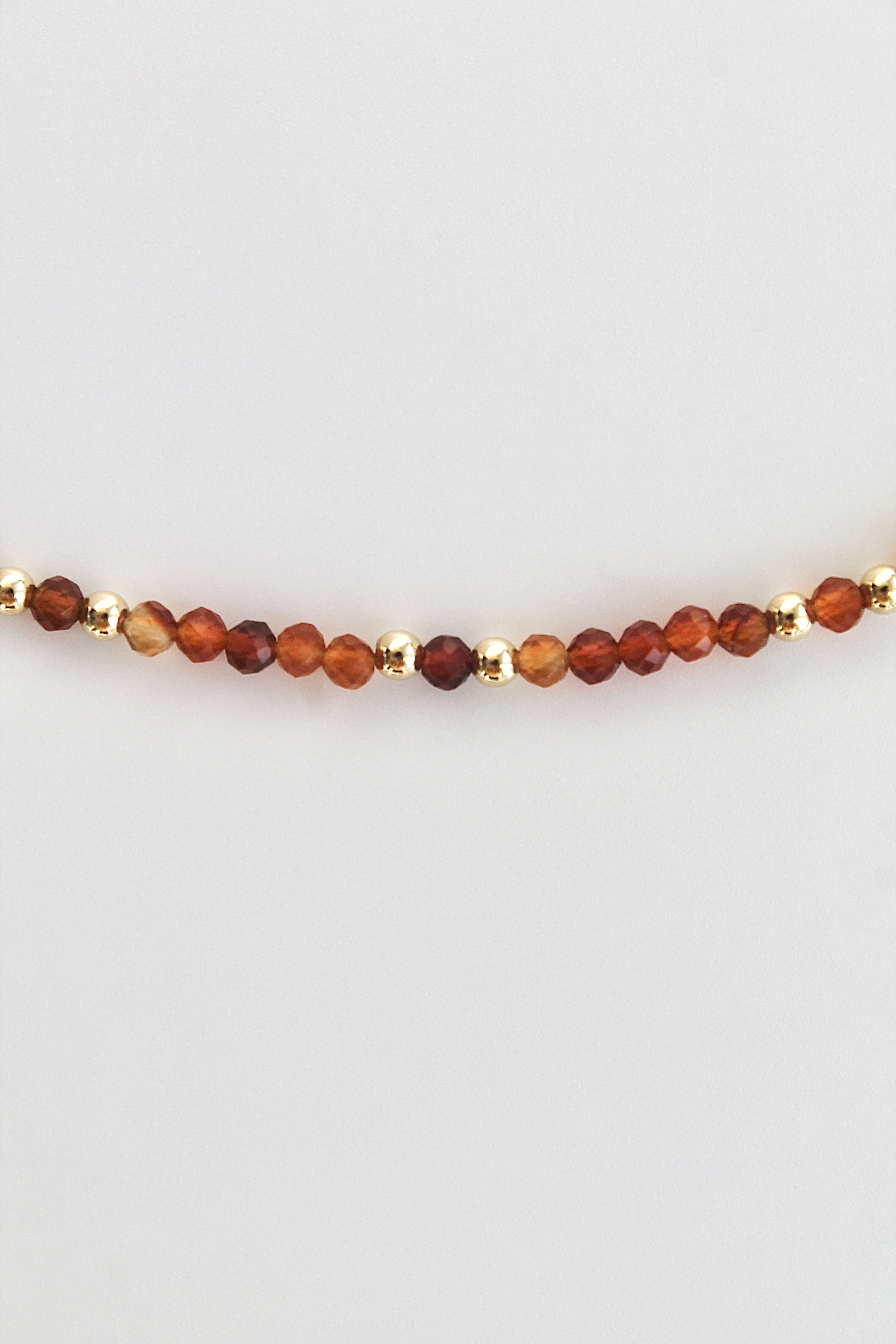 carnelian and gold bead bracelet on a white background