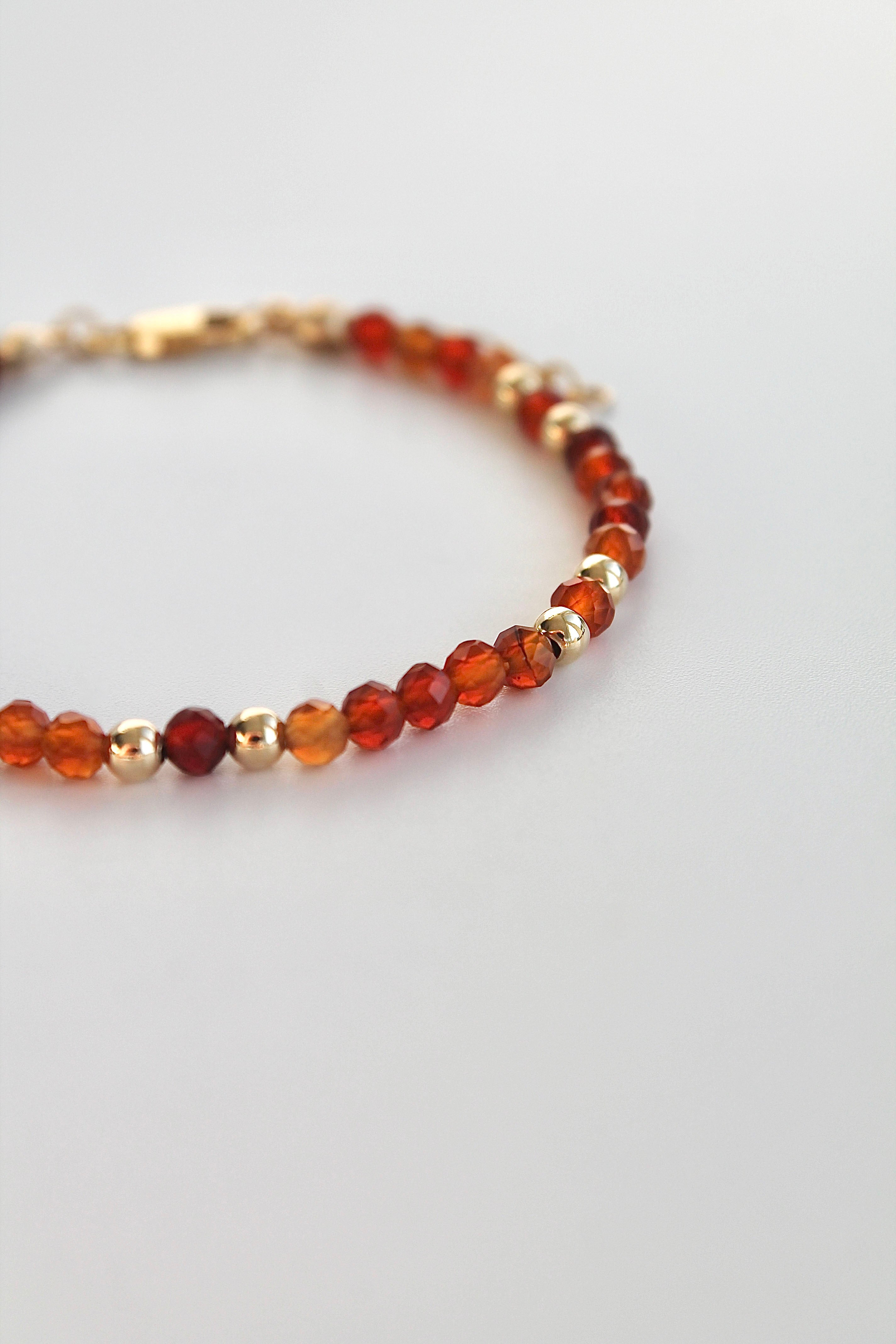 Bracelet with carnelian and gold beads on a white background
