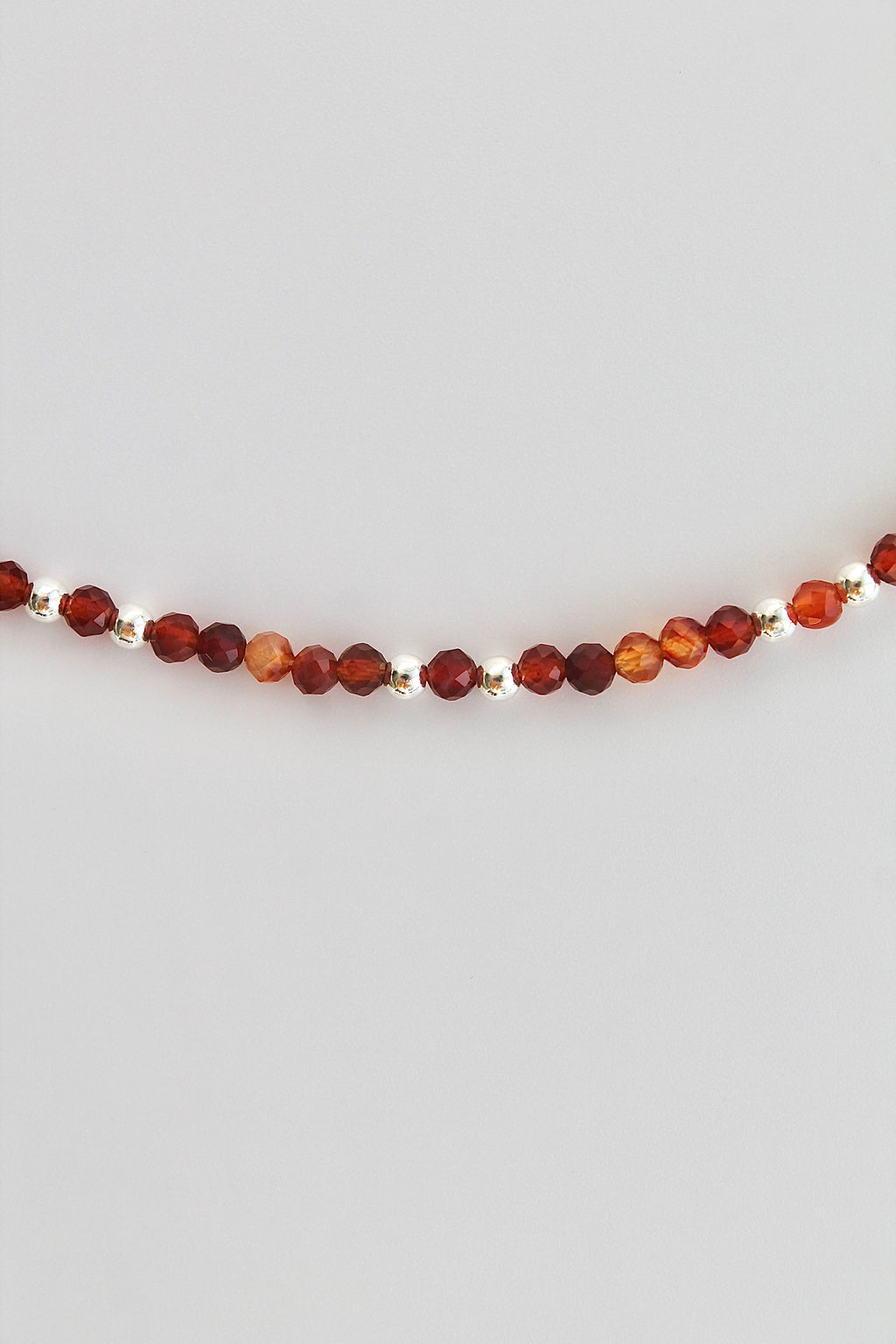 carnelian and silver beaded bracelet on a white background