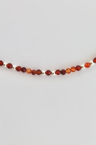 carnelian and silver beaded bracelet on a white background