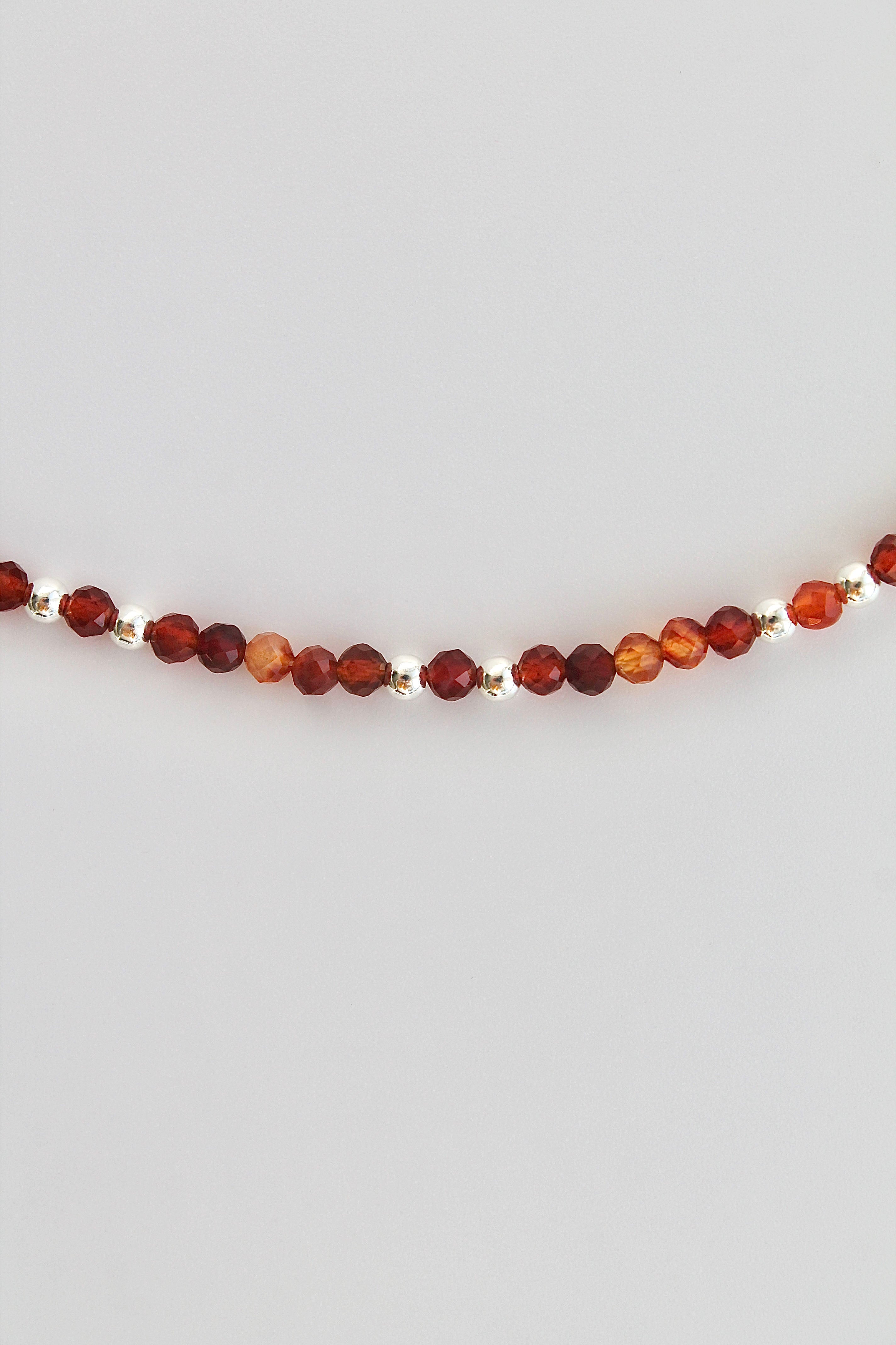 carnelian and silver beaded bracelet on a white background