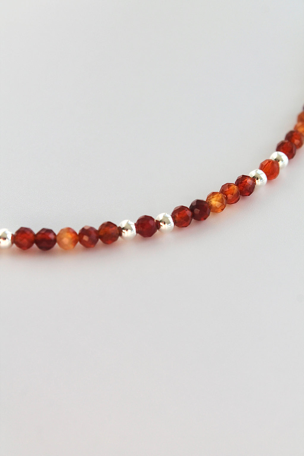 carnelian and silver beaded bracelet on a white background