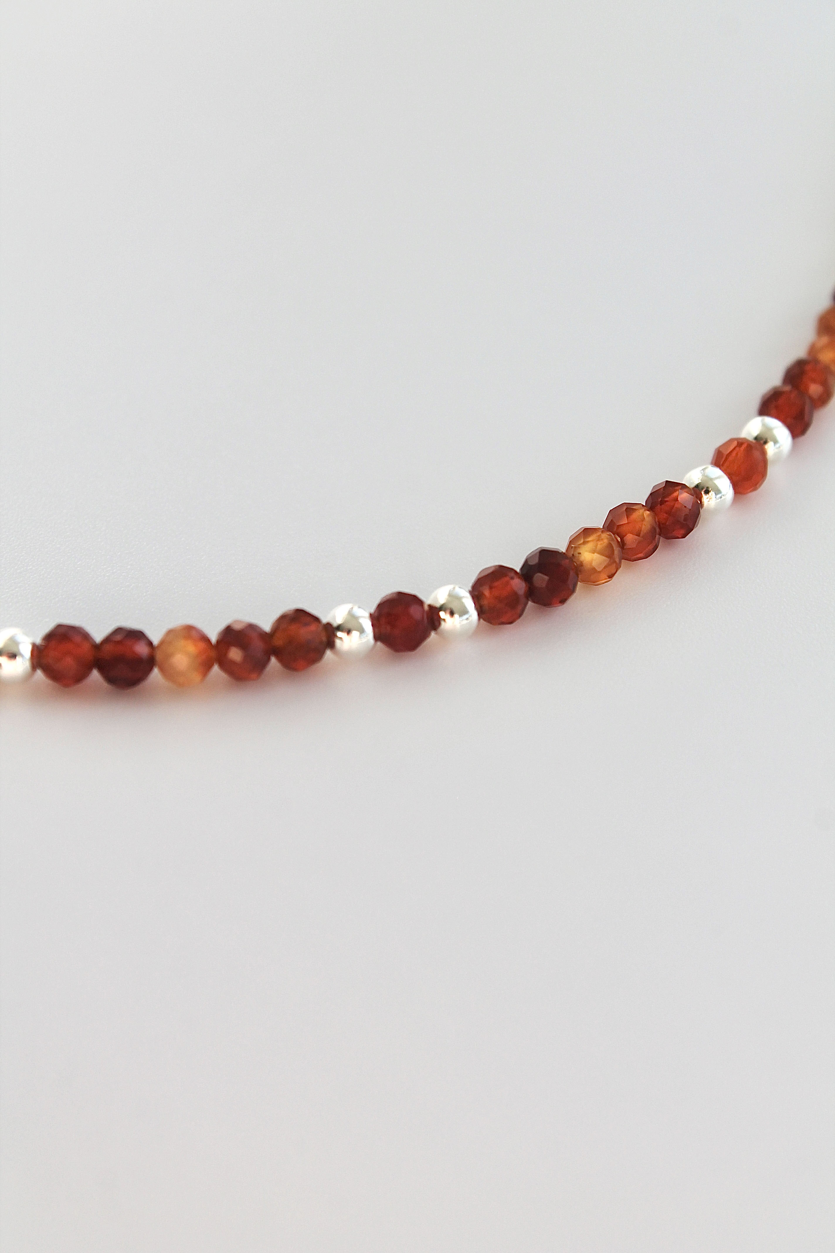 carnelian and silver beaded bracelet on a white background