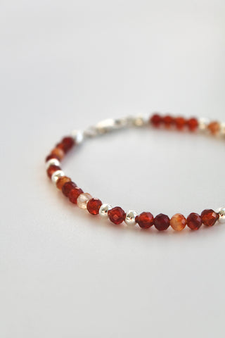 Beaded bracelet with carnelian and silver beads on a white background