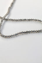 string of 3mm labradorite gemstones on a white background