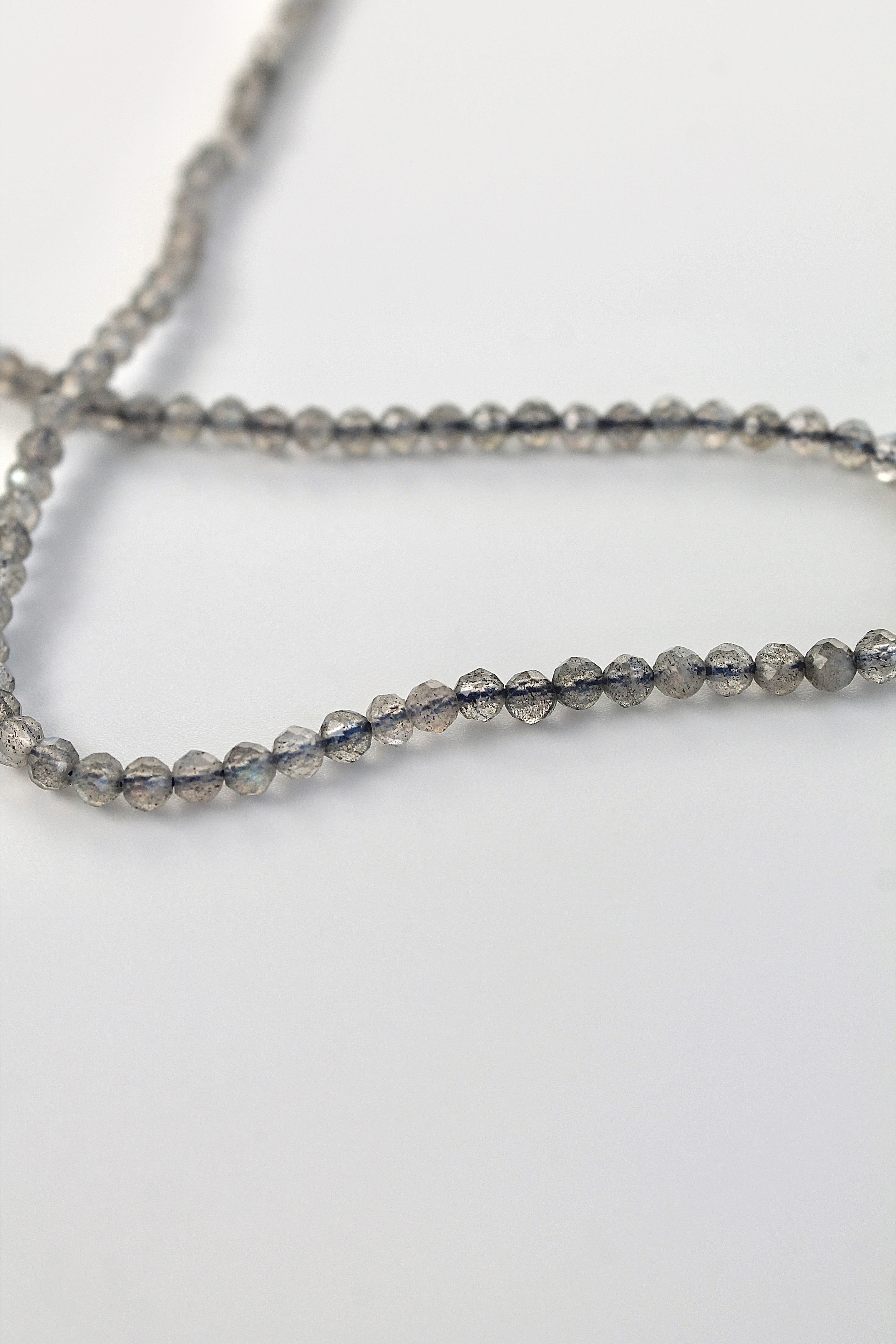 string of 3mm labradorite gemstones on a white background