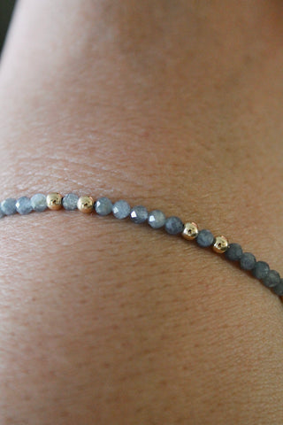 3mm sapphire gemstone and gold bead bracelet close-up on a wrist