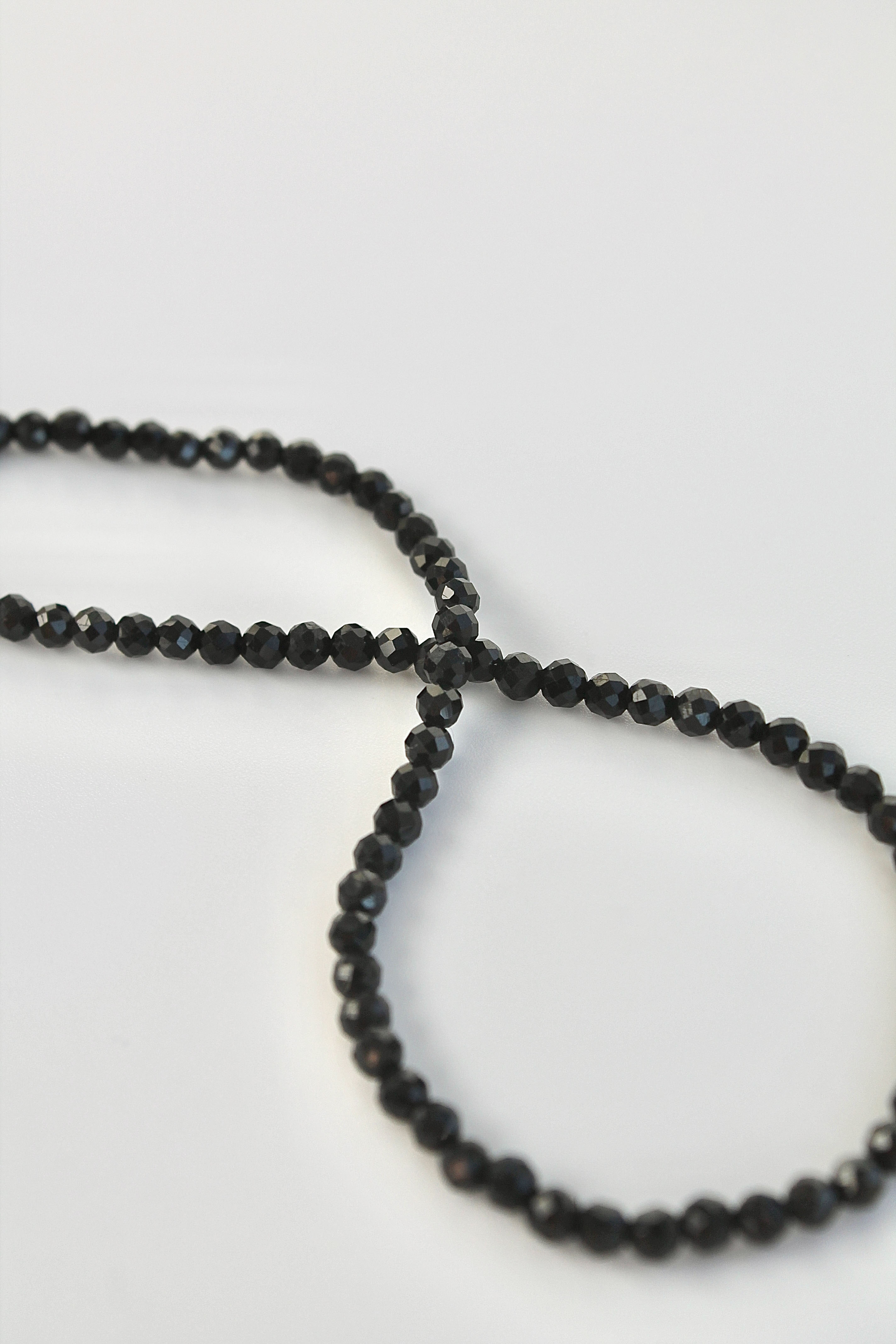 string of black tourmaline 3mm gemstones on a white background